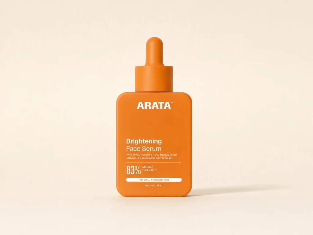 A clear studio photo of an orange Arata Brightening Face Serum bottle standing alone on a warm cream surface, the same bottle carried through every photograph in the set.