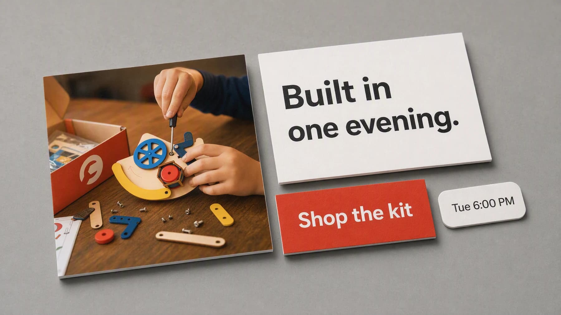 A complete social post laid out as physical cards on a grey studio surface: a square photo of a child assembling a build kit, beside a headline card, a red button card, and a posting time chip.