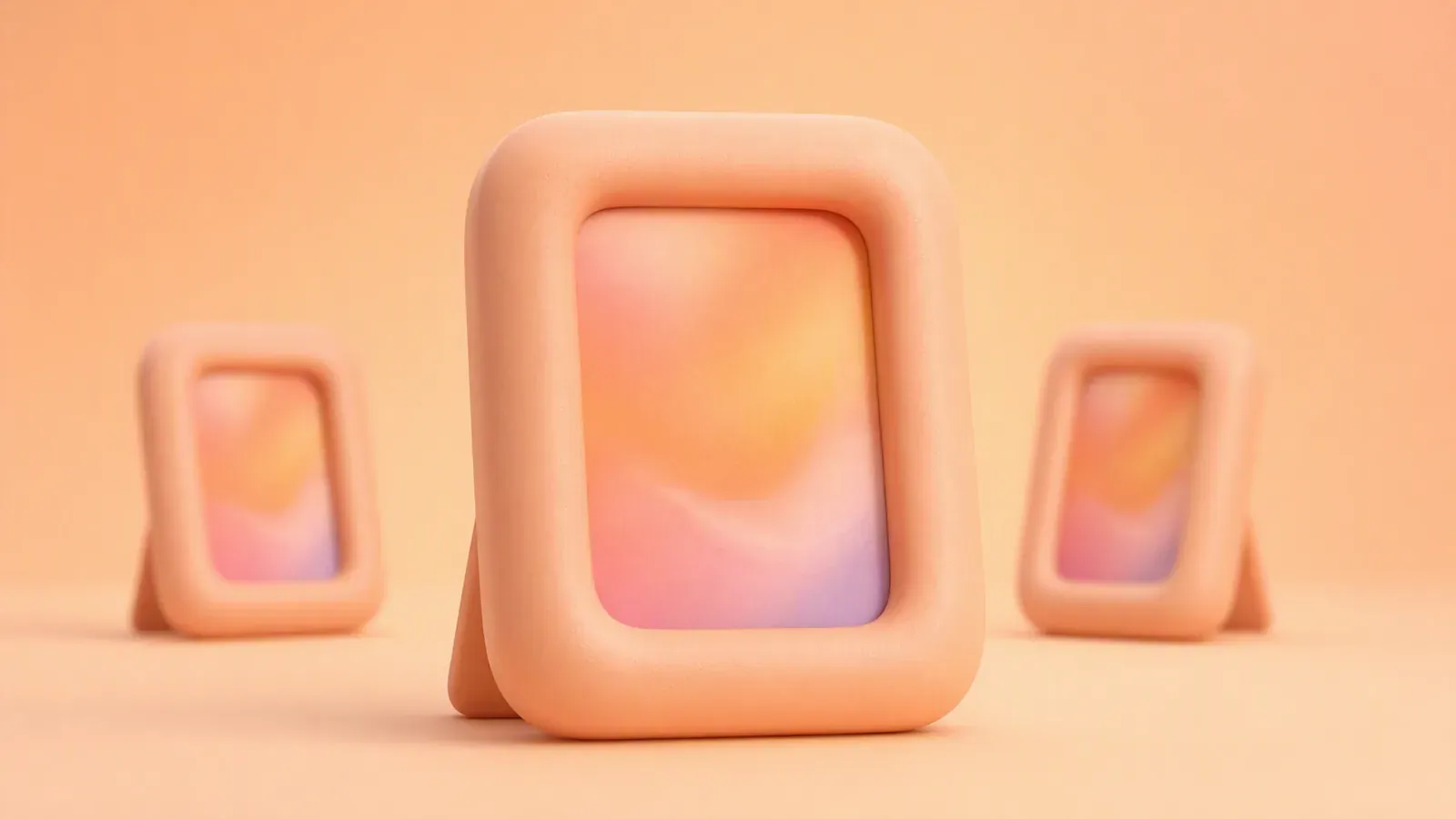 One large rounded clay picture frame standing in front of two smaller matching frames on a peach gradient background